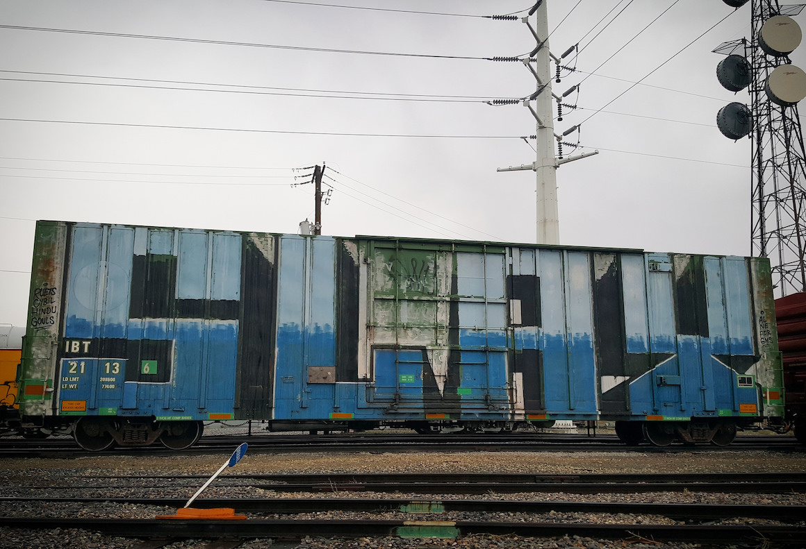 a shipping container with the word "slay" spray painted on it