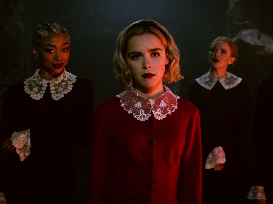 Three girls standing in dresses with lace collars